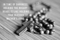 Rosary inspirational quote - In time of darkness, holding the rosary beads is like holding your blessed mothers hand. With Rosary and Jesus Christ holy cross crucifix in black and white background.