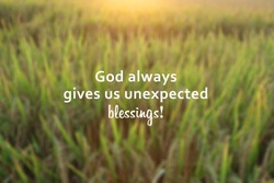 Inspirational quote - God always gives us unexpected blessings. With blurry background of dreamy morning sunrise light over the field. Believe in God concept.