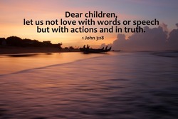 Bible verse quote - Dear children, let us not love with words or speech but with actions and in truth. 1 John 3:18 On colorful sunrise background over the fishing beach.