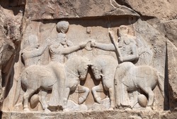 Stone bas-relief of Investiture of Ardashir I (Coronation of Ardashir I), royal tombs in ancient necropolis Naqsh-e Rustam, Achaemenid dynasty, Fars province, Iran. UNESCO world heritage site