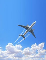 Vertical nature background with aircraft and Jet trailing smoke in the sky. Airplane and condensation trail. Foggy trail jet and plane in blue sky with white clouds. Traveling the world concept