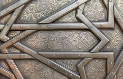 Detail of metal door with traditional islamic ornament. Copper window shutter with antique and national moroccan floral pattern. Oriental ornaments with artistic with chasing for brass