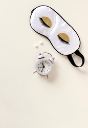 Flat lay composition with sleep eye mask, dream book and alarm clock on background. Healthy sleeping concept.