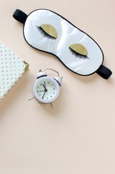 Flat lay composition with sleep eye mask, dream book and alarm clock on background. Healthy sleeping concept.