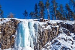Karelia. Russia. Frozen waterfall in the canyon. Karelian waterfalls. Snow-covered rocks. Ruskeala. Northern nature of Karelia. Winter Karelia. Travelling to Russia.
