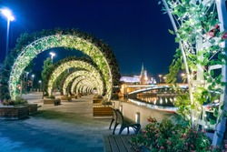 Moscow. Russia. Flower arches on the shore of the Kremlin embankment. Decoration of Moscow at night. Flowers on the evening promenade. Flower arches glow at night. Vacations in Russia.