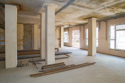 Large room during the repair. Pipes lie on a construction site. Building is ready for decoration. Preparation for communications. Engineering communications in a building under construction
