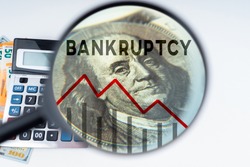 Bankruptcy of people and businesses. Falling graph under magnifying glass. Money and calculator. Concept bankruptcy law. Human bankruptcy court. Financial collapse. Failure from financial obligations