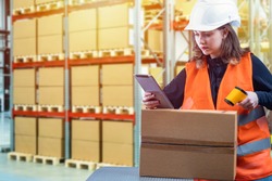 Customs registration. Girl with a scanner in the warehouse. Woman works on customs. Woman uses a barcode scanner. Passage of goods across the border. Customs officer registers postal items.