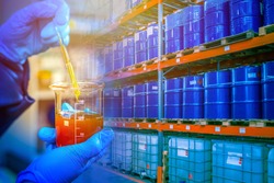 Warehouse chemical products. Concept - crude oil in blue barrels. Oil is prepared for export. Laboratory assistant took a sample for verification. Checking oil products for quality. Barrel shelving