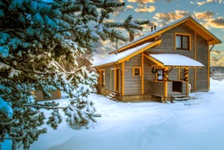 Vacation home. The cottage is covered in snow. Snowdrifts near the cottage. House away from the city. Concept - Christmas holiday away from the city. Northern nature. Wooden cottage on a winter day
