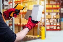 Checking goods using a portable barcode scanner. Scanner for reading barcode in human hands. Warehouse employee holds small boxes. Storage equipment. Concept - sale of barcode scanner.