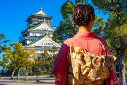 Japan. Geisha near palace in Osaka. Imperial Palace. Girl dressed as a geisha with her back to camera. Ancient landmarks of japan. Woman in national Japanese clothes. Travel to Osaka. Japan Tourism