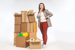 Old things in boxes. Concept - unnecessary personal items in woman's boxes. She thinks about storage space. Woman with boxes on light background. She needs place for personal storage