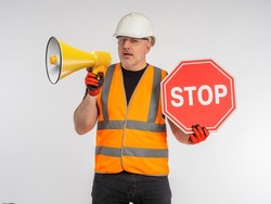 Restriction due to renovation work. Stop sign in man hand. Builder or road worker with megaphone. Danger due to road work. Red prohibiting sign in hand of builder. Ban concept.