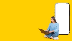 Big phone behind woman. Girl is sitting with laptop. Big blank smartphone. Layout for application. Female student on yellow background. Screen of giant mobile phone. Template for educational ads
