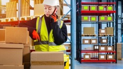 Customs specialist. Warehouse specialist talking on phone. Passage of parcels through state custom. Concept of customs clearance of goods. Border control. Woman in yellow vest talking on phone