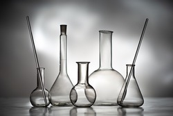 Flasks for reagents. Laboratory glassware monochrome. Medical glass flasks. Chemical laboratory tube on grey. Test tube for laboratory diagnostics. Empty flasks for chemical analysis.