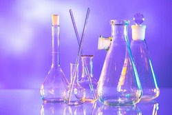 Laboratory test tubes. Flasks on table. Test tubes for medical research. Dishes for medical experiments. Glass medical flasks on violet. Laboratory glassware. Laboratory flask for science.