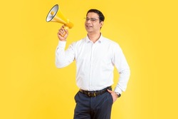 Happy man with megaphone. Positive Indian guy loudspeaker. Human with megaphone. Young businessman advertises something. Loudspeaker as marketing metaphor. Male in shirt with megaphone