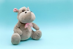 Stuffed animal hippo on blue background. Child soft toy, comforter for sleep. 