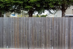 An older wooden privacy fence with no markings, background texture.