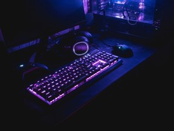 gamer workspace concept, top view a gaming gear, mouse, keyboard with RGB Color, joystick, headset, webcam, VR Headset on black table background.