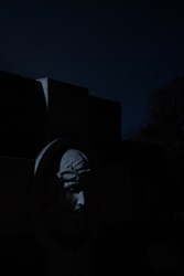 non-existent sculpture cemetery tomb view of marble face at night time with game of light and shadow, vertical photography with star sky background space 