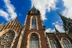 Christian architecture cathedral building perspective foreshortening from below of high walls with arch windows and brick texture exterior of towers