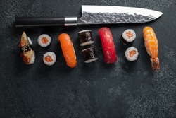 Different Sushi with Japanese knife on concrete.
