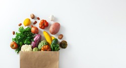 Delivery healthy food background. Healthy vegan vegetarian food in paper bag vegetables and fruits on white, copy space, banner. Shopping food supermarket and clean vegan eating concept.