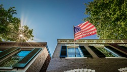 A flag flying on a sunny morning from a building in Alexandria, Virginia.