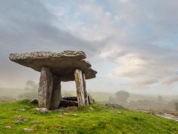 Poulnabrone Dolmen relict building in County Clare near Ballyvaughan town, famous Burren area of Ireland, Beautiful sun rise sky, Green grass in foreground. Fine example of Irish history