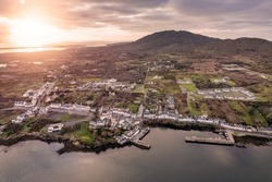 Aerial drone view on fishing town Roundstone in county Galway, Ireland located on Wild Atlantic Way route. Tourism and fishing industry. Beautiful Connemara nature scenery. Errisbeg the background.