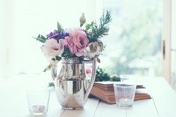 Summer bouquet of purple and pink eustomas in an antique coffee pot on white wooden table, vintage style, holiday and wedding floral decorations