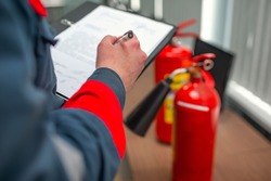 Engineer Professional are Checking A Fire Extinguisher Using Clipboard or checking Industrial fire control system,Fire Alarm controller, Fire notifier.System ready In the event of a fire.
