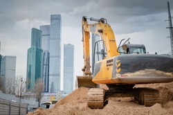 construction machinery and excavator on the background of skyscrapers. concept of building buildings, bridges and roads