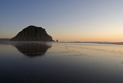 Horizontal image of Morro Rock and its reflection at sunset on Morro Beach, with copy space.