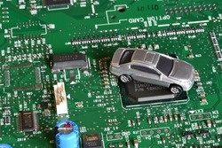 Toy cars on electronic board and microchip. Conceptual image for semiconductor shortage disrupting production of the automotive industry.