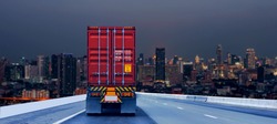 Truck on road with red container, transportation concept.,import,export logistic industrial Transporting Land transport on the expressway driving to Night City