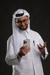 Doha Qatar January 14 2023: Qatari Man Holding smart phone posing in studio various expression