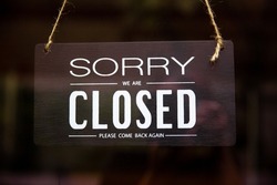 Sorry we are closed sign hanging on the front door when covid-19, coronavirus, closed signage symbol for the coffee shop is close.