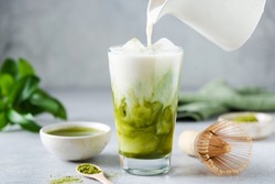 Soy milk pouring in matcha ice tea. Healthy vegan drink
