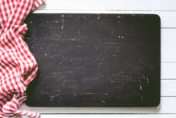 Black wooden cutting board and red plaid textile. Food background with copy space, Horizontal