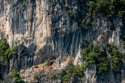 Close up of a rocky cliff. Stones texture Background. Steep cliff of high mountain. Nature background, geological structure.