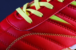The texture of a red sneaker closeup. Part of leather sports shoes.