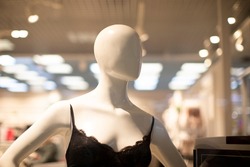 Mannequin of a woman in a bra in a shop window.
