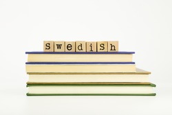 swedish word on wood stamps stack on books, language and academic concept