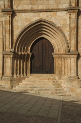 Big wooden door with labored medieval stone arches and steps on the Santa Maria la Mayor Church at Trujillo. A small medieval town, birthplace of the Conquistador Francisco Pizarro in western Spain.