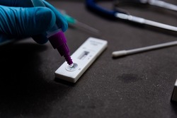 A person is seen doing a rapid antigen test for SARS-CoV-2 or Covid is seen on a table with nasal swab stick during a rapid surge in demand due to the Omicron variant of Covid19